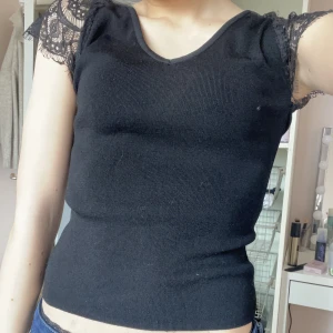 T-shirt med spets ärm - Super fin svart vringad t-shirt med spets ärmar från mango