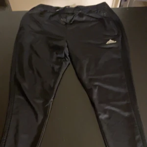 Adidas träningsbyxor  - Adidas träningsbyxor i svart och med dragkedja vid fötterna