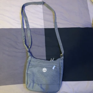 Axelväska | Topmove - Axelväska som jag inte längre använder. Inte en datorväska. Är justerbar och har inga defekter. Fler bilder kan skickas vid begäran. 