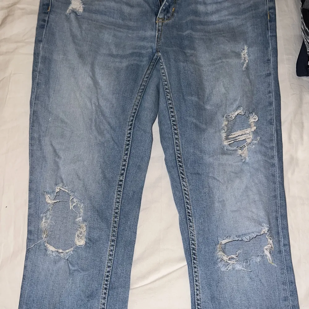 Blåa jeans med hål och lägre i midjan . Jeans & Byxor.