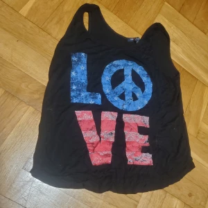 Linne med tryck "Love" - Svart linne med tryck "Love" i USA-färger. Som ni kan se är det cat-approved 🐾 (men tvättar självklart innan jag säljer)!  Okej att komma med bud. 