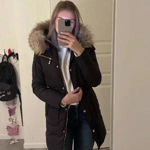 Vinterjacka hollies  - Jättefin varm dun vinterjacka från hollies, med äkta päls. Endast använd 1 vinter och är i jätte bra skick. Jackan har 4 fickor och en dragsko som man kan dra åt i midjan. Är i storlek 34 men passar även 36/38. , pris kan diskuteras vid snabb affär 