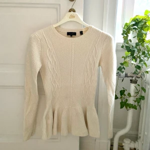 Stickad tröja med volang - Stickad tröja från Ted Baker London i storlek UK 2 (passar mig som bär 34-36).  Varm och fin tröja med volangkant längst ner. Nypris runt 1200kr