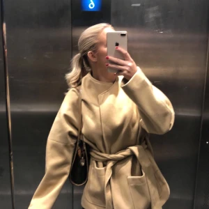 Kort kappa  - Säljer min beige bruna kappa från hm! Jätte fin kappa nu till hösten med rymliga fickor och en jätte fin pass form! Jackan är i bra skick men kommer inte till användning så mycket längre! Köpte står för frakt 