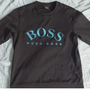 Hugo Boss tröja med blå text. Storlek M. Använt cirka 10 gånger. 