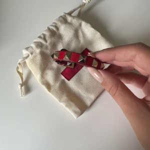 Valentino rockstud armband  - Säljer mitt valentino rockstud armband i rött! Säljs med alla tillbehör samt äkthetsbevis. Använt ca 5 gånger (nyskick) och säljer pga att den inte är min stil. Köptes för 2200 kr på hemsidan 