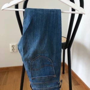 Lee-jeans - Från Lee. Använda men fint skick. Hölje för skärp är sönder på två ställen, går säkert lätt att fixa. Ganska låga, sitter tight. Skulle tippa på strl s. Dragkedja längst ner vid benet. Är lagom längd för mig som är 162cm.