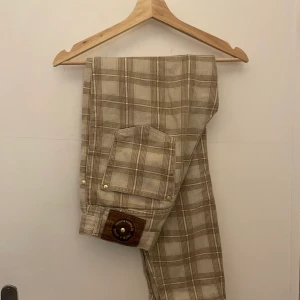 Rutiga byxor - Högmidjade byxor, köpta secondhand, står ingen storlek men skulle gissa på W26 L29. Säljer dem då de är lite korta på mig som är 170, passar nog perfekt på någon som är 160-165. 