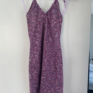 Virkad klänning från pull & bear  - Virkad lila/rosa/vit klänning med halterneck knytning från pull & bear. Aldrig använd, prislapp kvar. Storlek L men passar S/M