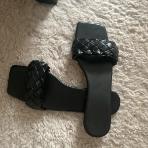 Svarta tofflor  - Ett par nya svarta tofflor 