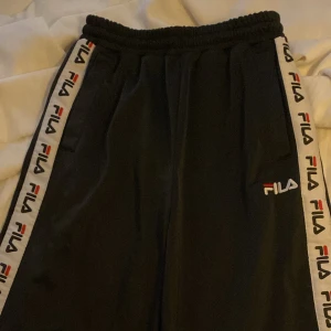 Fila byxor  - Raka Fila byxor med knappar hela vägen på sidorna. Köpta för 1200kr men pris kan diskuteras 