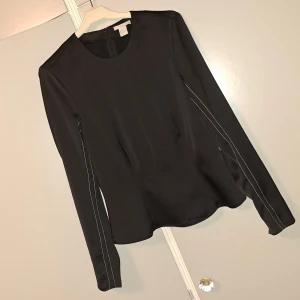 Satinblus med utsvängda ärmar - Säljer denna satinblus från H&M storlek 36. För 99 kr nypris 299 kr. Bra skick.  Passar alla kroppstyper. Formar kroppen fint. Vita detlajer, lite puffiga axlar, ärmdetlajer, midjedetaljer, fin hals skärning.  Ger en busniesswoman, chick, elegant vibe