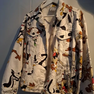 Jeansjacka med seriefigurer - Vit jeansjacka med seriefigurer från Looney Tunes. Använd endast ett fåtal gånger, så är i mycket bra skick. Står storlek s men är oversized så passar bra på m. Finns att hämta i Nacka alternativt kan jag skicka. Hör gärna av dig vid funderingar :).