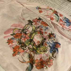 Tröja med tryck - Cool tröja, med tryck både på ryggen, ärmen och litet tryck på framsidan vid bröstet typ. Har en luva! Hör av dig vid frågor!