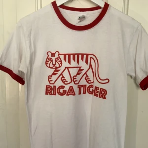 Snyggaste bandtröjan? - Svensk indies snyggaste merch gör Riga Tiger. Smärtar att sälja denna pärla men nu har den hängt i garderoben för länge. Aldrig använd