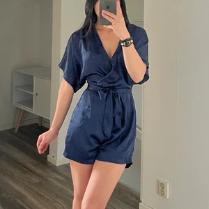 Jumpsuit Nelly.con XS - Marinblå jumpsuit i satin från Nelly i storlek XS. Underbar nu till sommaren och så så fin med stickad tröja över. I fint skick. Köparen står för frakten som tillkommer på 66kr spårbart med postnord, annars finns den att hämtas i Göteborg 💙