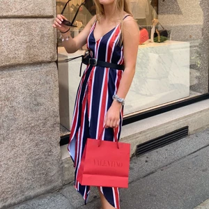 Randig satinklänning strl 36 - Snygg randig satinklänning från Linn Ahlborg x NAKD i storlek 36 med knytning i midjan och slits framtill. Endast använd en gång💃🏼🦋✨✨ (Obs skärpet på bild 1&2 hör inte till klänningen och ingår inte).