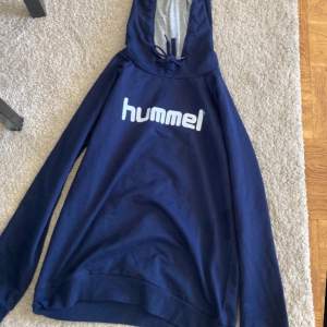 En mörkblå Hummel hoodie i storlek m bra passform inte jätte tjock material men väldigt mysig (frakt ingår inte)