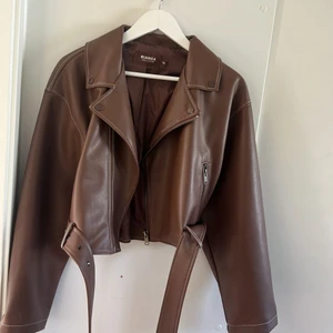 Skinnjacka  - Brun skinajacka från biancas kollektion med Nelly. Skitsnygg jacka med superfin passform och med ett bälte man kan ta bort om man vill. Säljer för den inte kommit till användning, använd få gånger. 