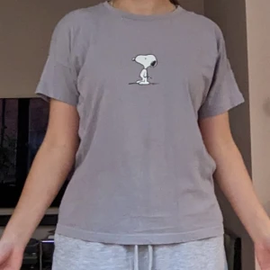 Babytee - Ljuslila babytee med Snobben tryck. 