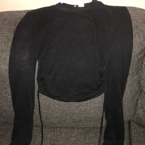 Rygglös tröja  - Långärmad. Knyta runt midjan. Var i ryggen. Aldrig använd 