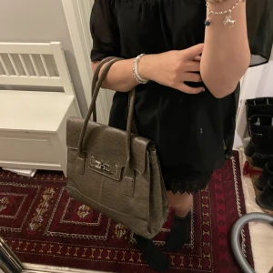 Väska - Säljer denna fina väska. Den är i bra skick dock finns det lite slitningar längst kanten men den är rymlig! Brun med prickar. Kommer inte till användning tyvärr. Köpte på sellpy