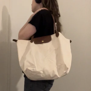 Vit Longchamp - Krämvit väska från Longchamp, funkar till stranden eller använda som vanligt. Finns ett fåtal fläckar men annars i väldigt bra skick🌷