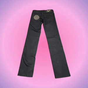 Lågmidjade jeans med detaljer - Säljer mina så coola Madonna seven7 jeans som jag tyvärr inte får på mig😭😭 De är köpta secondhand men aldrig använda av mig och i nyskick med prislapp kvar! De är svarta/mörkblå i färgen och alla rhinestones är kvar⭐️ Skriv privat vid intresse o frågor💖💖🕺🏼