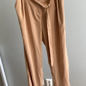 Na-kd byxor med skärp - Helt oanvända byxori beige och svart från Na-kd. Båda för 250 kr 