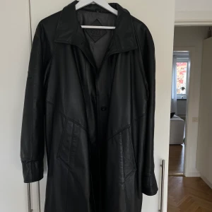 Svart skinn kappa - Svart skinn kappa i stl 40  Inköpt 1999 och endast använd vid enstaka tillfällen så den är i nyskick!   Material: äkta skinn  Färg: svart  Stl: 40