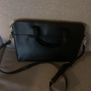 Stilig, fin datorväska  - Säljer min oanvända datorväska/laptopväska. Svart. Axelrem och handtag. Fickor. Passar laptops upp till 13,0 - 14,0 tum. Elegant och fin datorväska för kvinnor. 