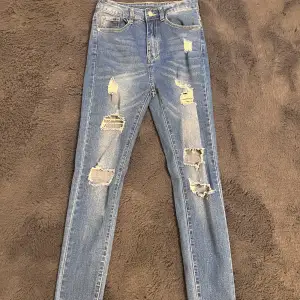 Blå jeans med slitningar, storlek Xs.  Använda 1 gång.