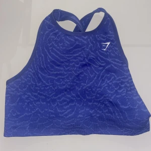 Gymshark sport-bh  - Lila sport-bh i storlek M från gymshark. Är typ en blandning mellan sport-bh & crop top. Den är i fint skick. Aldrig använd. Nypris: 499kr Kan mötas upp i Göteborg eller skicka på post men då betalar köparen frakt🤍