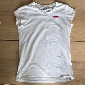Levis t-shirt - Det är en vit t-shirt med ett rött Levis märke. Den är i storlek 152. Den passar då alltså till barn/ungdom. Frakten är 39  kr.