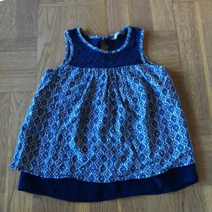 Linne - Ett blått jättefint linne med mönster och spets på uppe i halsen i stl 128.