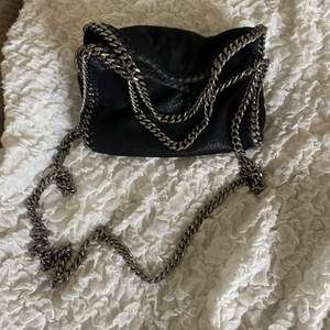 Väska från Stella McCartney, klassisk falabella mini med crossbody kedja. Ej kvitto kvar då det var en födelsedagspresent. Svart. Botten av fodret på insidan har några fläckar, annars superfint skick.