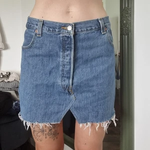 Vintage retro levi's 501 kjol - Levis 501 jeanskjol. Vintage/ retro. Gammal storlek enligt lapp w42 l30 = M. Kortmodell med låg midja.. Midja: 40cm rakt över. Längd i mitten fram 37cm. Se andra annonsen för mer bilder