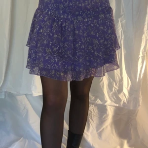 Lila kjol - Blommig lila kjol, med smock i midjan. 