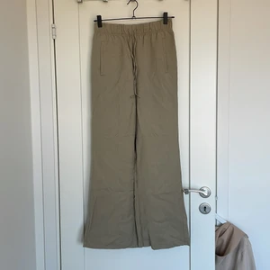 Byxor med slits - Ett par olivgröna tyg byxor med 2 fickor fram och en bakficka. Tjuster bara snören och 2 slits baktill. Sitter jättefint på o h jätte sköna. Stl s men sitter mer som xs/s. Nypris 399kr  Finns att hämta i jönköping eller postar 