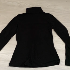 Svart polotröja  - En svart polotröja. Den är väldigt snygg och bekväm och sitter väldigt bra. Väldigt stilren och enkel att styla