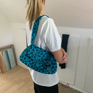 Väska blå - Väska i mjukis/teddy material. Superfin med leoprint i en fin blå färg. Köpt second hand. Använder tyvärr alldeles för lite. Den har ett innerfack skicka dm för fler bilder. Köpare står för frakt som kostar 66kr. Spårbart
