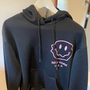 Hoodie  - Svart hoodie med smiley i ena hörnet, under smileyn står de new york U.S.A  Använd ett par gånger, fint skick! 