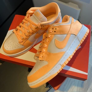 Nike Dunk Low ”Peach Cream” - Säljer dessa Nike Dunk Low ”Peach Cream”. De är helt nya och oanvända. De köpta ifrån JD Sports och givetvis äkta. Storlek 38,5. Bara att höra av sig vid frågor!