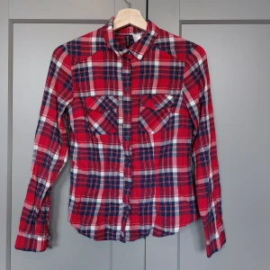Rutig flanellskjorta röd och blå strl 34 - Rutig flanellskjorta röd och blå strl 34. Jättefint skick.
