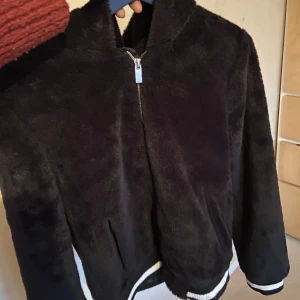 Fluffig pälsjacka  - Säljer min super fina fuskpäls jacka då den inte kommer till någon användning längre. Den är extra fin nu till våren och har två fickor och en luva. Bara blivit testad men inte andvänd köpt på nelly för 400kr💗