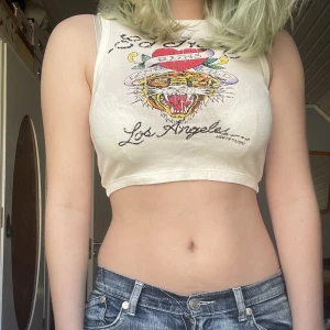 ed hardy linne - ett ed hardy linne/tanktop! ett tunt/stretchigt material och öpen i ryggen så perfekt för sommaren 🥰några rhinestones/strass vid texten