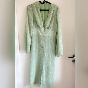 Grön långklänning med knappar  - Säljer denna klänning, perfekt till sommaren. Lite för liten för mig så hoppas nån kommer passa bättre i den. Bra skick, knappt använd. Ganska öppen klänning och har en del knappar. Tight modell. 