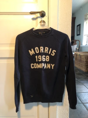 Morris knitted sweatshirt  - Ännu en till favorit, perfekt för sommarens kvällar! Stilren, funkar med skjorta och t-shirt under.  Färg: marinblå, med vit text  Skick: 9/10 Nypris: 1500 kr  Mitt pris: 250 kr  Storlek: XS