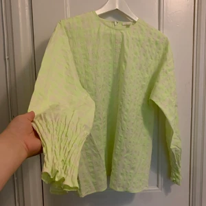 COS blus - Långärmad blus från COS i vitt-/ljust neongulgrön-rutigt. Ingen krage, dragkedja i ryggen. Smock längst ut på ärmarna. Aldrig använd.