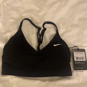 Nike sport-bh  - Svart sport-bh från Nike med spännbara band. storlek xs. Helt oanvänd och prislapp kvar. Nypris 329kr. Köparen står för frakt. 